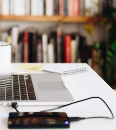 Close up detail view of a white work desk with laptop, hard drive and coffee Close up detail view of a white work desk with laptop, hard drive and coffee