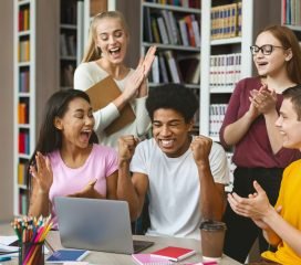 Group of young euphoric students enjoying test results in library Hire in Global E-Book Typing Project